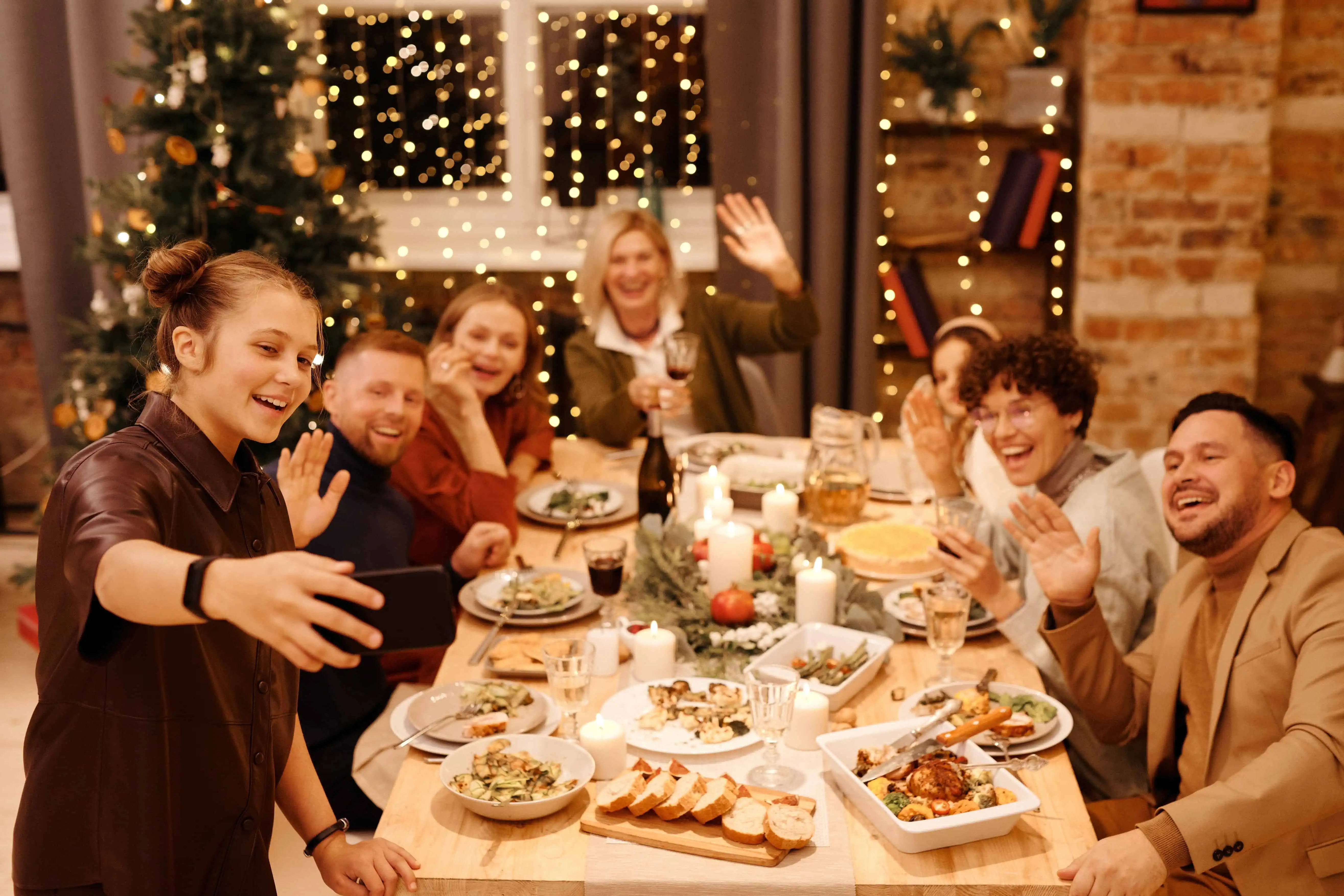 A picture of a smiling family having a meal together looking at the camera.