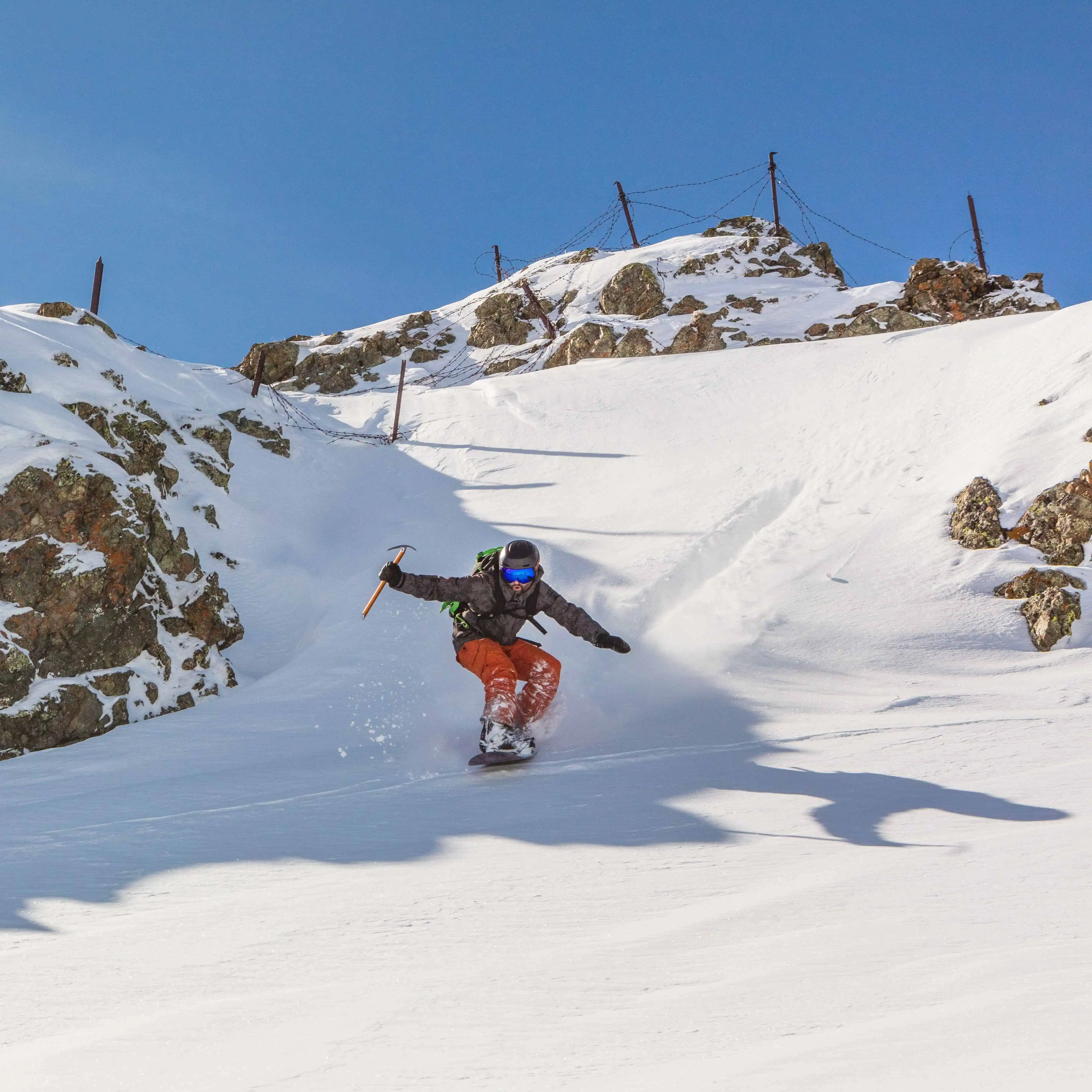 A picture of someone snowbording down a hill twords the camera.